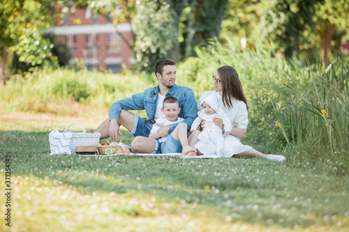 Young beautiful family having lunch by the lake. Summer picnic. © Kristina89