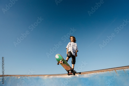 Kid with skateboard on ramp in skatepark