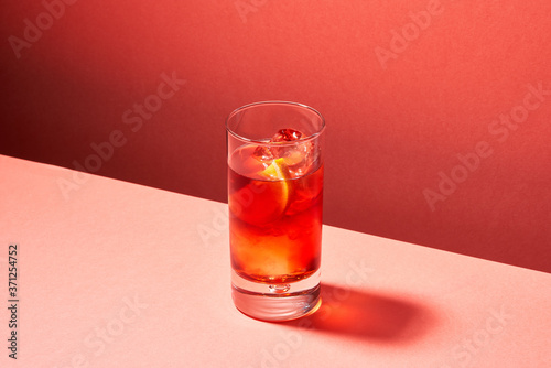 Tasty red drink with ice and oranges