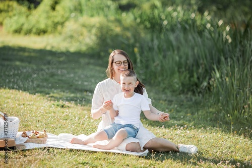 Young beautiful family having lunch by the lake. Summer picnic. photo