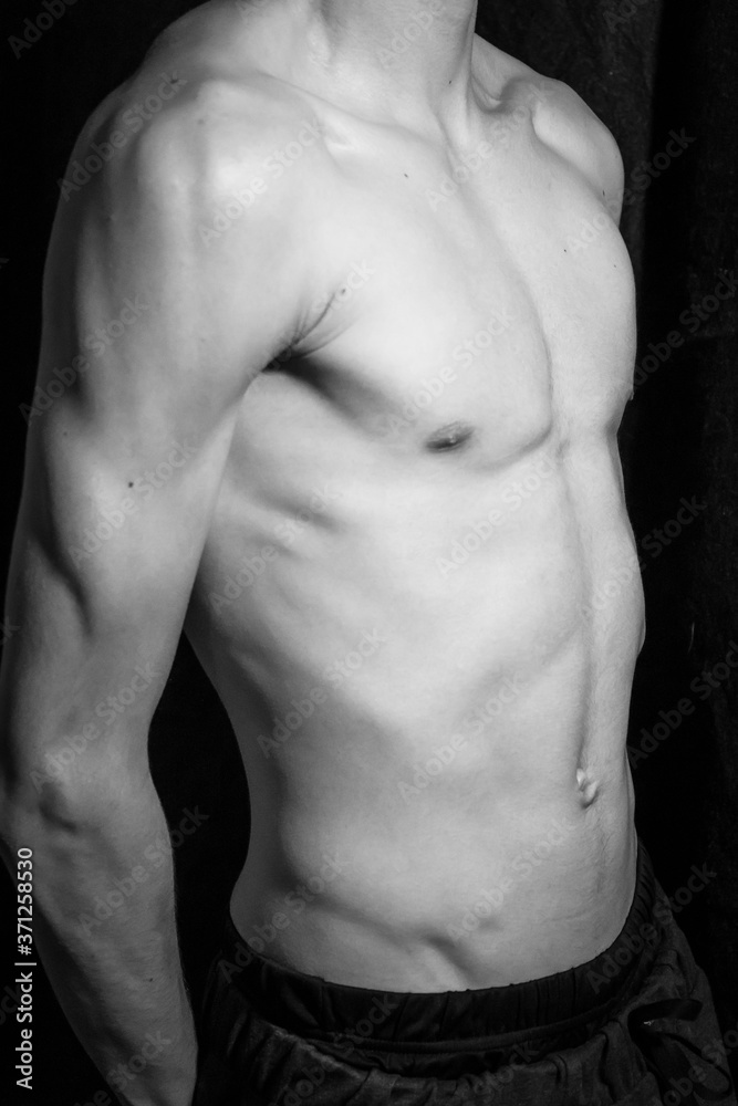 Medellín, Antioquia / Colombia. September 07, 2019. Muscular male torso on a black background