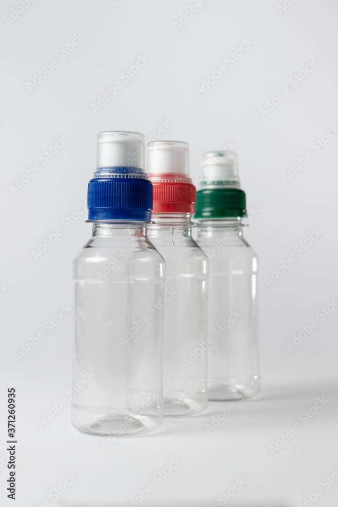 Three small clear plastic bottle with lid. White background. Three small clear plastic bottle with lid. White background.
