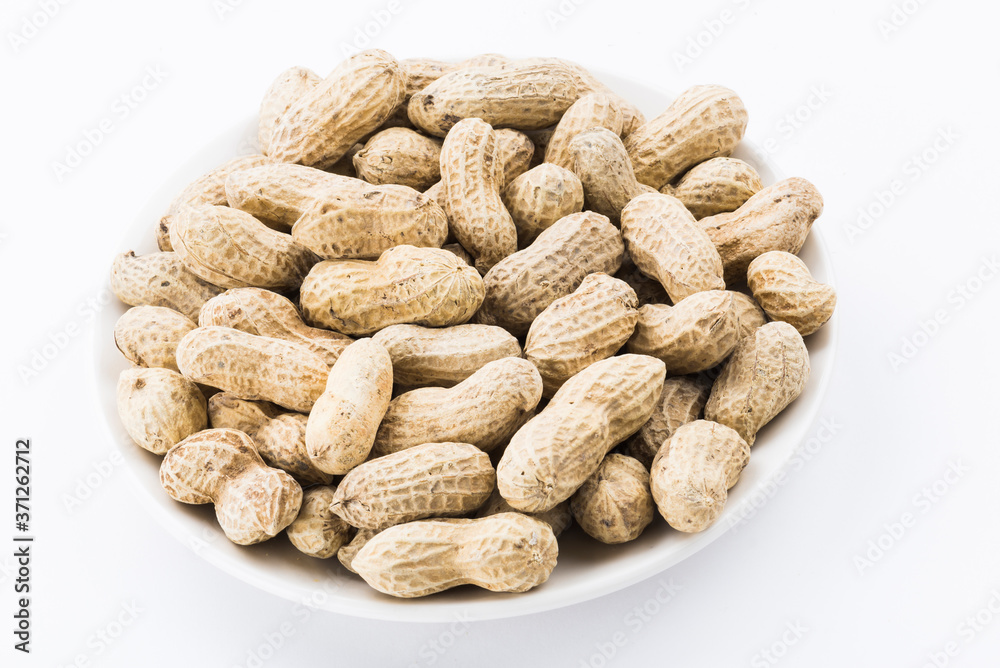 Close-up of delicious peanuts on a white dish Close-up of delicious peanuts on a white dish