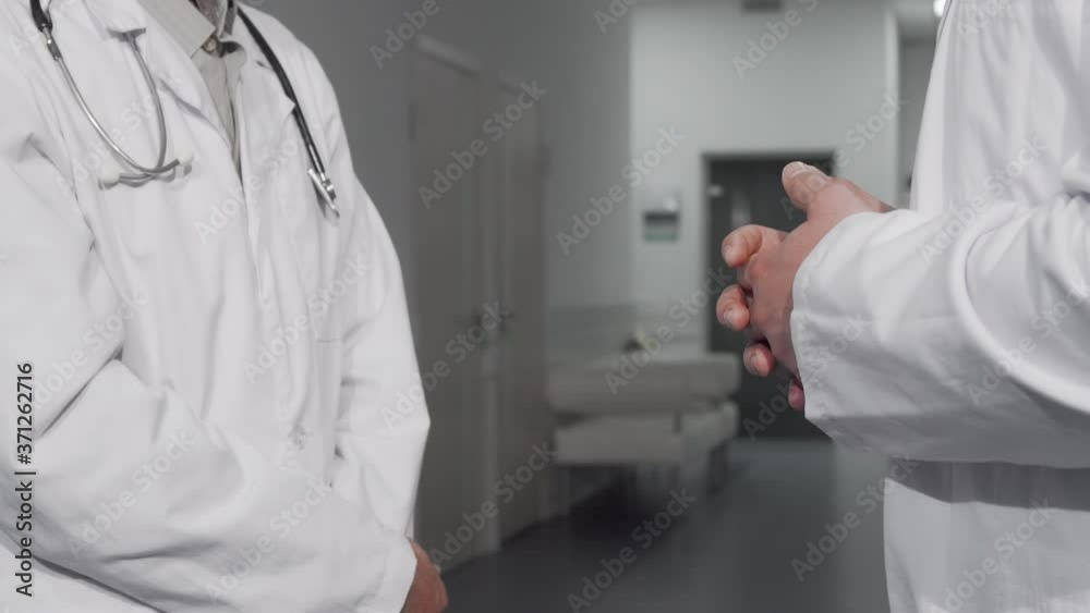 Unrecognizable doctors shaking hands at the hospital. Cropped shot of two medical workers in labcoats shaking hands. Teamwork, partnership, trust concept Unrecognizable doctors shaking hands at the hospital. Cropped shot of two medical workers in labcoats shaking hands. Teamwork, partnership, trust concept