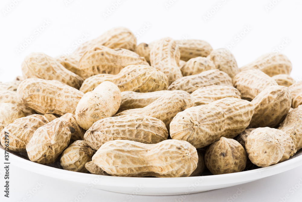 Close-up of delicious peanuts on a white dish Close-up of delicious peanuts on a white dish