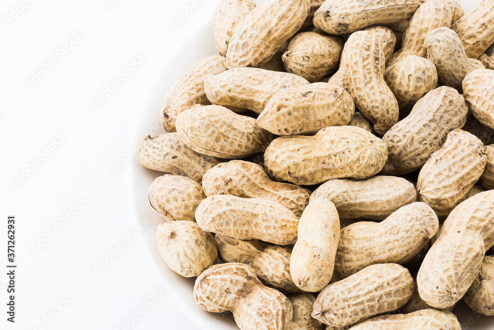 Close-up of delicious peanuts on a white dish Close-up of delicious peanuts on a white dish