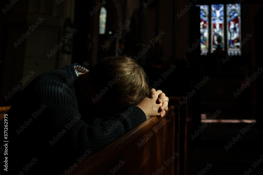 Man bows his head in prayer in Church. Man bows his head in prayer in Church.