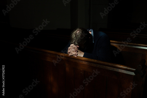 Man bows his head in prayer in Church. photo