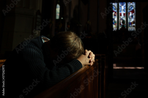 Man bows his head in prayer in Church. photo