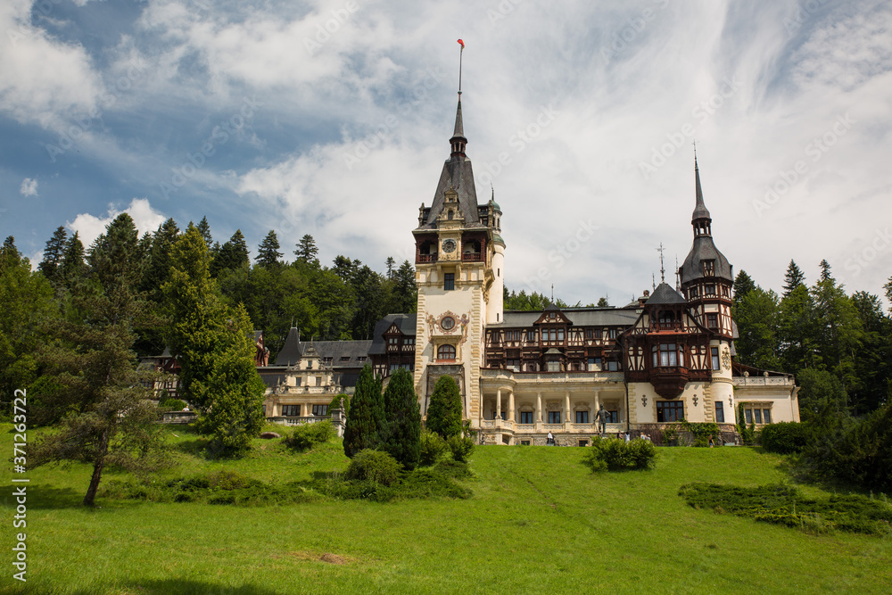 Panoramic view of Peles Castle, Romania. Famous Neo-Renaissance castle and ornamental garden in Sinaia, Carpathian Mountains in Europe.