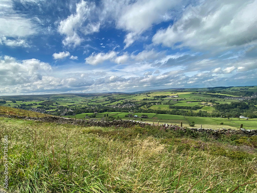Landscape, with long grass, dry stone walls, fields, hills, and valleys looking toward Lancashire near, Haworth, Keighley, UK
