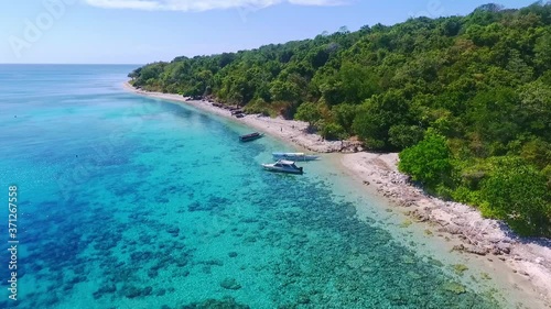 Aerial pull out shot over beautiful crystal clear beaches of Moyo island in Indonesia. photo