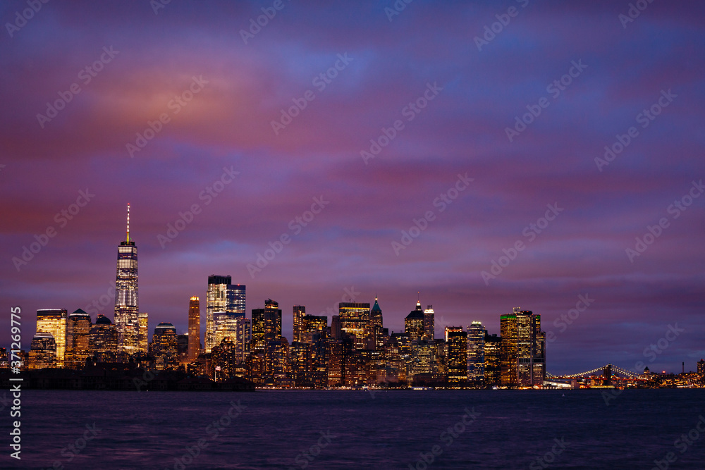 Obraz premium Wide panorama of a moody night view of New York Manhattan downtown over Hudson river