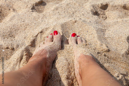 pieds aux ongles vernis dans le sable sur la plage photo
