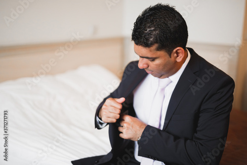 Grooms morning preparation. Handsome man getting dressed and preparing for the wedding photo