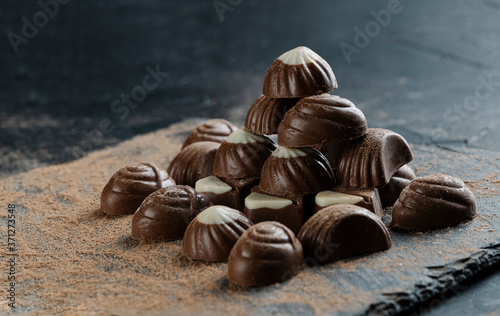 chocolate bonbons on black background with cocoa powder