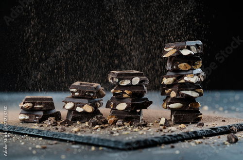 Obraz na płótnie pieces of chocolate with almonds on black background w salonie