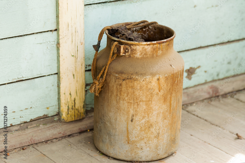 Big old metal jar. Selective focus. Tinted photo. Big old metal jar. Selective focus. Tinted photo.