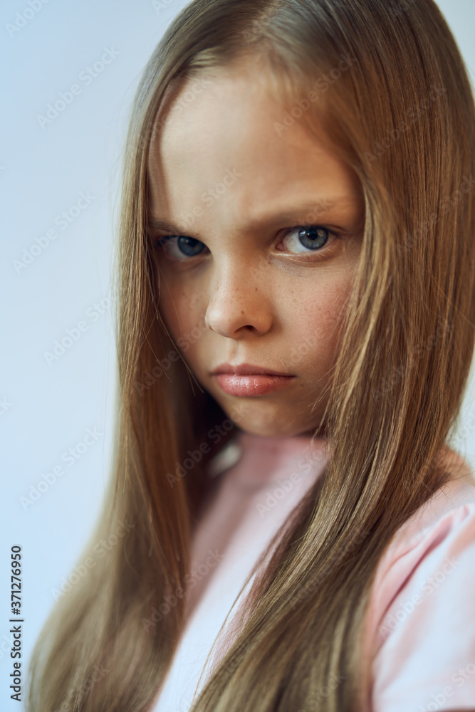 Girl with an unhappy expression on her face white t-shirt resentment emotions Girl with an unhappy expression on her face white t-shirt resentment emotions