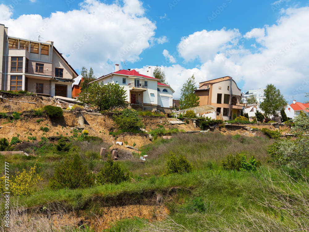 landslide caused by torrential rains of hurricane CHRISTIE. Broken road asphalt cracked, and came down with landslide. Destroyed residential buildings of cottage town elite settlement. earthquake
