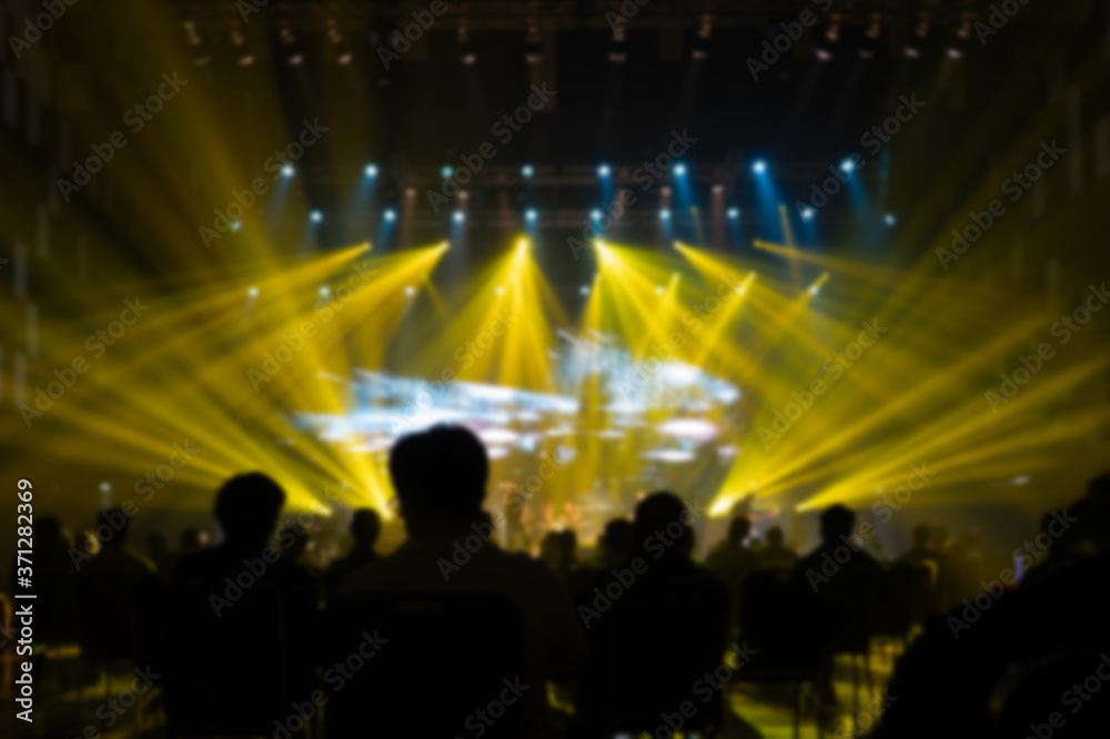 Texture blur and defocus Yellow lights.Performance.silhouettes of concert ,crowd of people at the music event