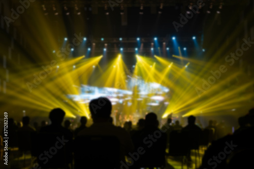 Texture blur and defocus Yellow lights.Performance.silhouettes of concert  crowd of people at the music event