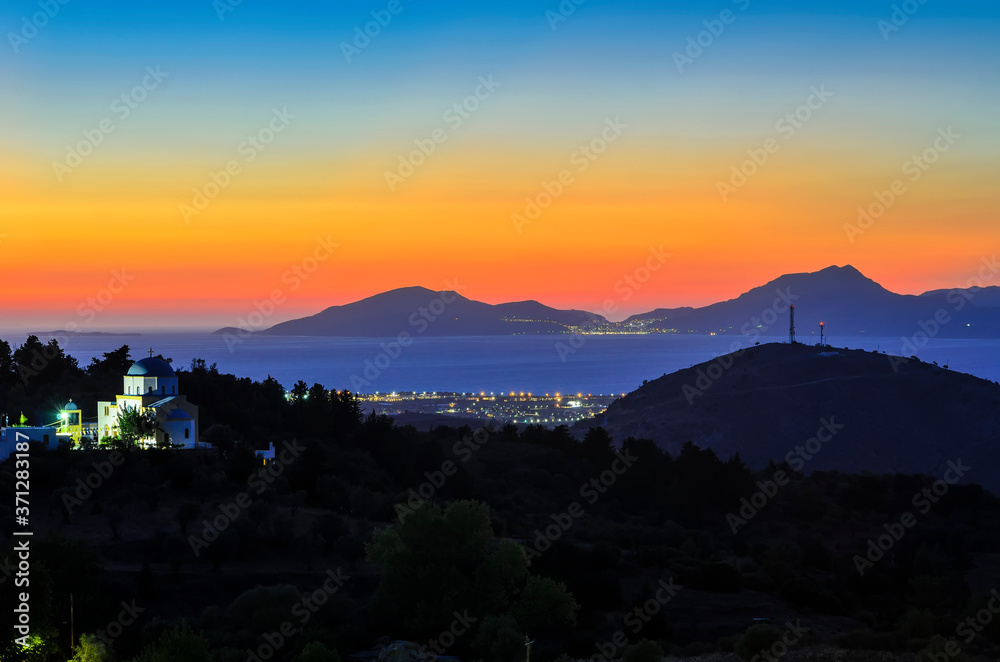 Blue hours after sunset on the island of Kos, view of the Holy Church of the Birth of the Virgin Mary, the Aegean Sea and the Greek island of Kalimnos. Greece