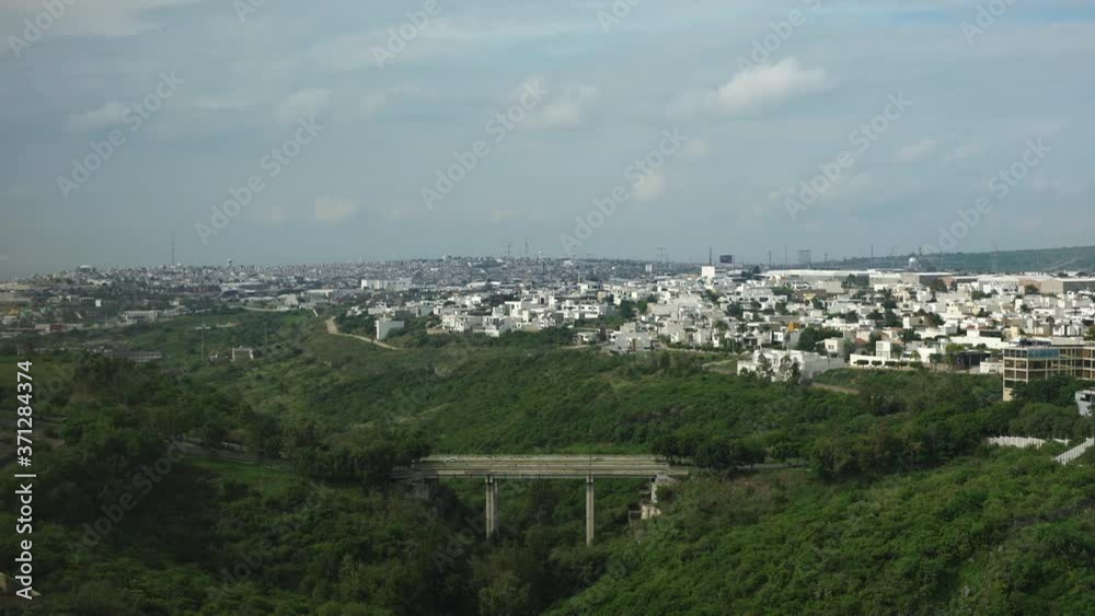 Time lapse of Leon, Guanajuato, Mexico with a blue sky, green forest and a small bridge. Urbanised city in Mexico. Time lapse of Leon, Guanajuato, Mexico with a blue sky, green forest and a small bridge. Urbanised city in Mexico.