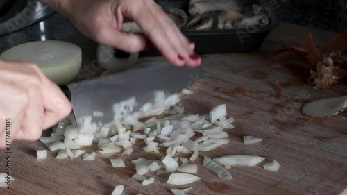 A woman's hands splitting vegetables on a wooden board in the kitchen
