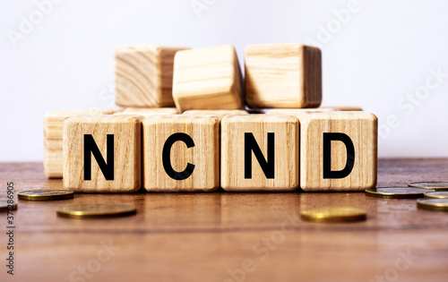 wooden cubes and NCND, coins, the concept of taxation, increase taxes and fees photo