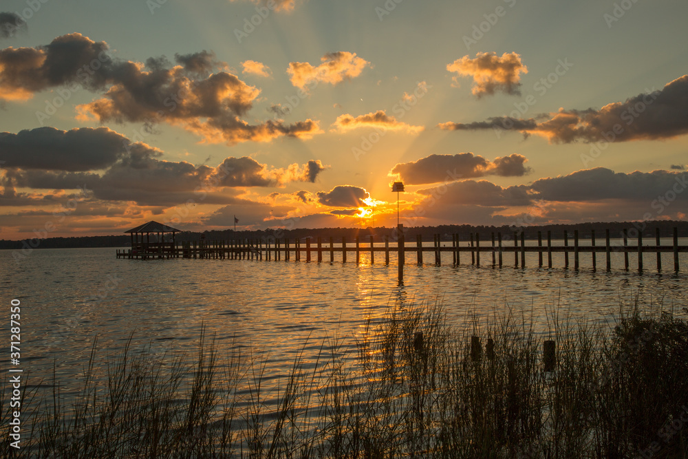A pier stretching out in Mobile Bay at sunset, at Fairhope Alabama.