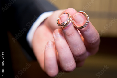 Gold wedding rings in the man's hand. Close up.