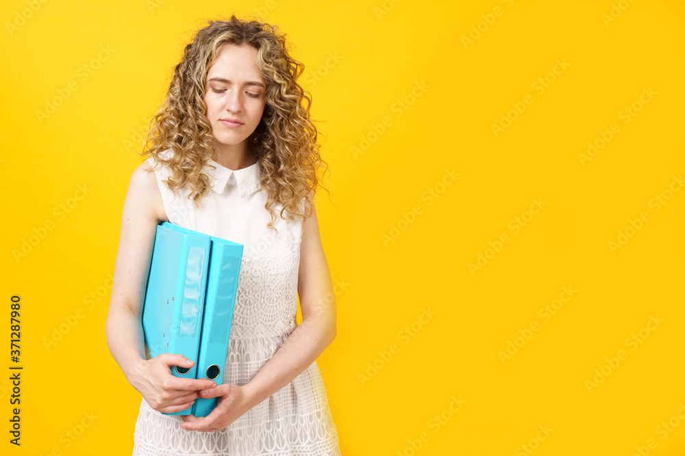 A young woman holds folders with documents in her hands. A young woman holds folders with documents in her hands.