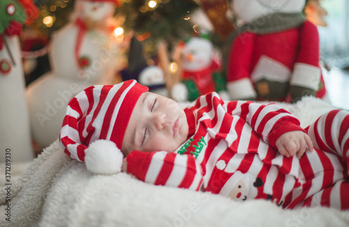 Baby sleeping by the tree the night before christmas 