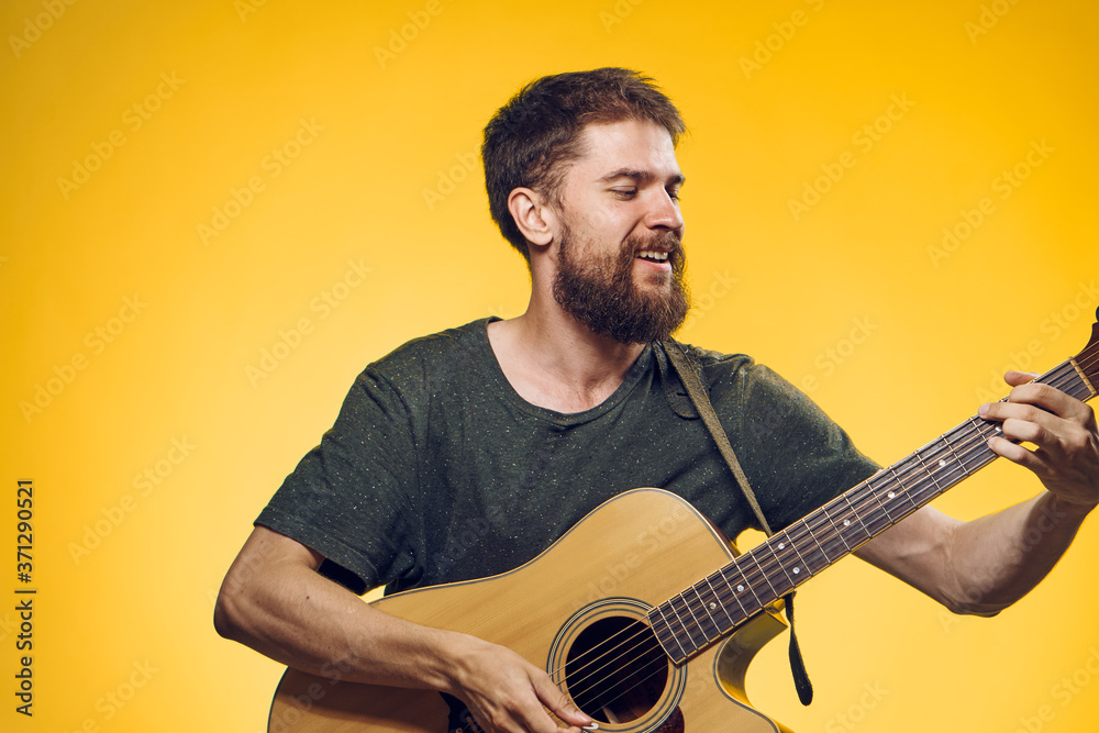 man playing guitar music performance lifestyle yellow background