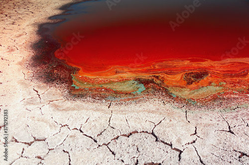 The drought, the dried-up pond, the cracked and salted earth, the remains of water in a muddy puddle. Background image of the concept of global warming.Selective focus.