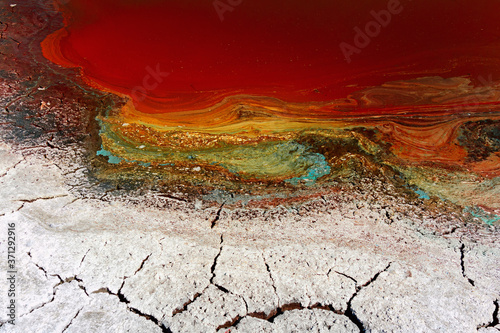 The drought, the dried-up pond, the cracked and salted earth, the remains of water in a muddy puddle. Background image of the concept of global warming.Selective focus.