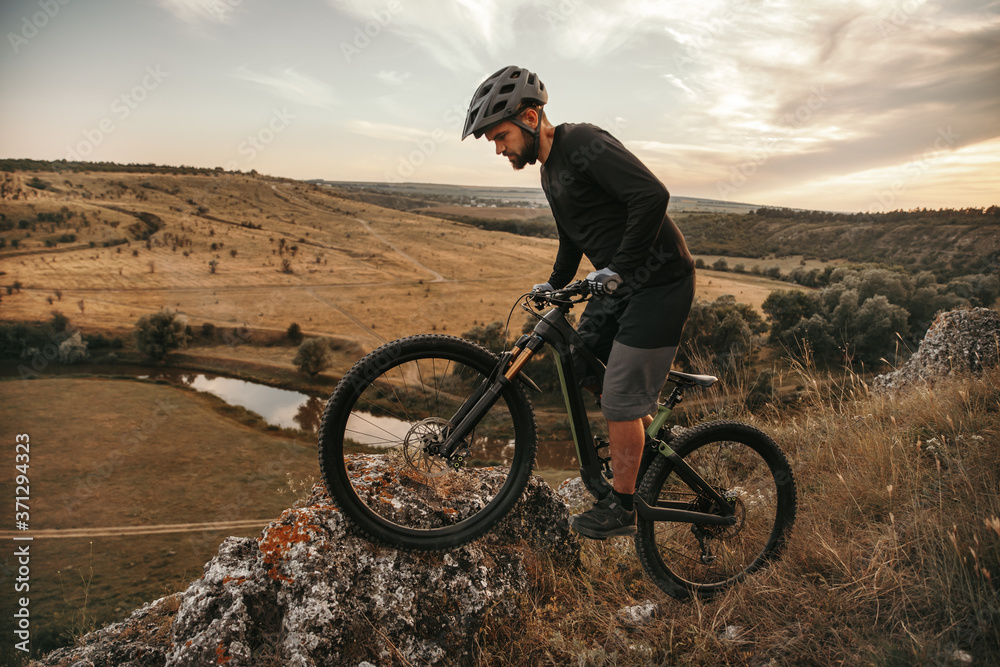Fototapeta premium Male cyclist on edge of cliff