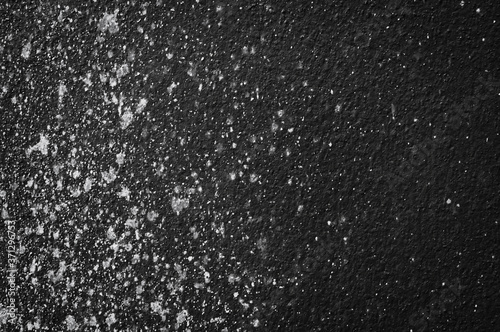 Wall grunge black concrete with light background. Dirty,dust wall concrete blackboard texture and splash white color space for text or abstract background.Soft focus image.