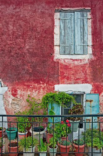 Front of an old house decorated with flower pots in Greece