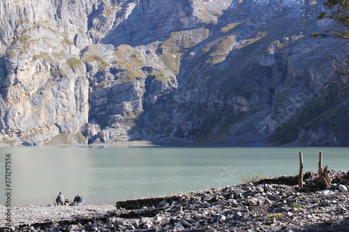 turqouise mountain lake infront of a rock face in the swiss alps photo