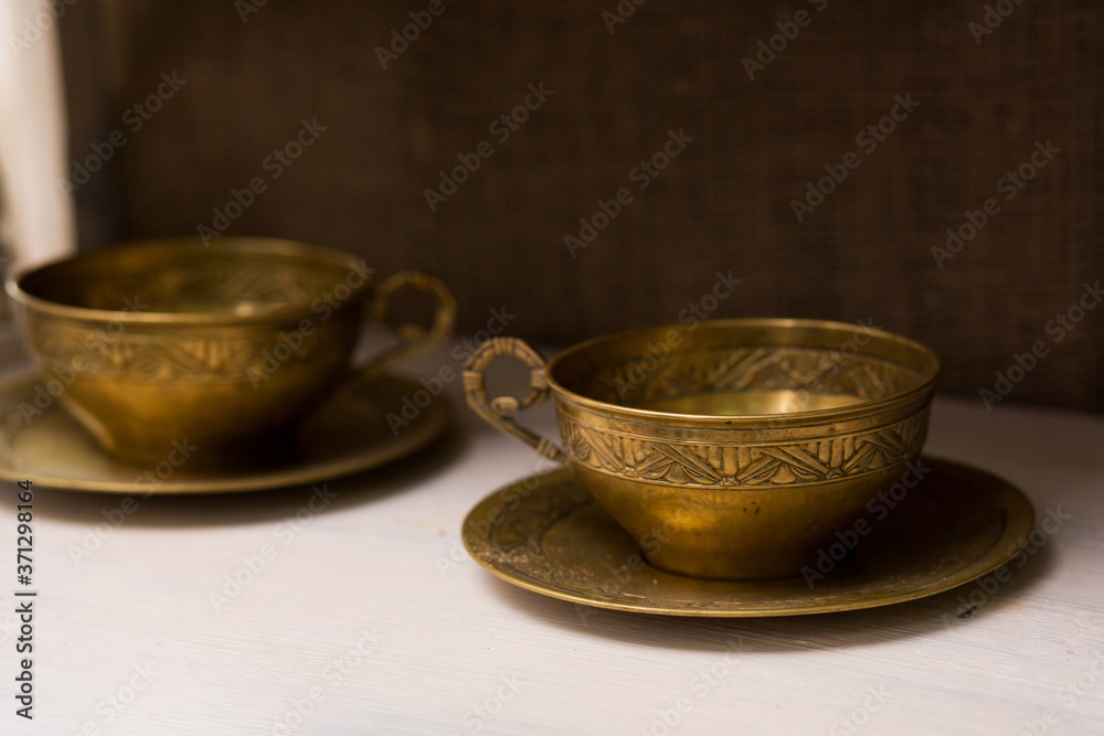 Fototapeta premium antique tea mugs with copper saucers. Unusual home decor items
