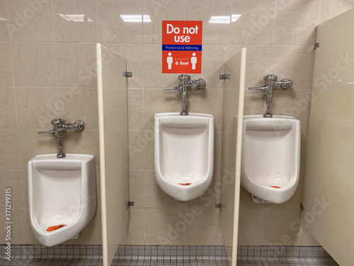Urinals in a men's room. One urinal is unavailable due to COVID-19 social  distance requirements Stock Photo | Adobe Stock