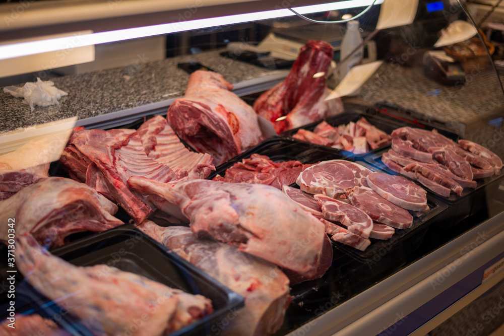 Meat cuts on display at the butchers shop. Chicken, lamb, pork and beef parts in a refrigerator.