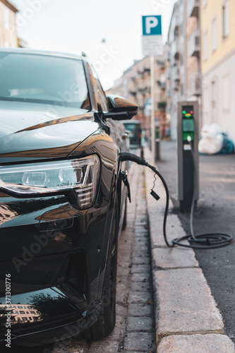 Luxury hybrid car charging battery on the street