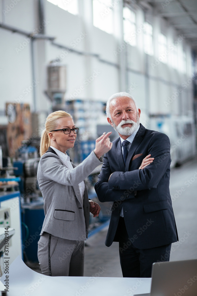 Man and woman discussing work. Colleagues working in factory Man and woman discussing work. Colleagues working in factory