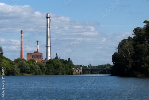 factory chimneys in a river and sky landscape