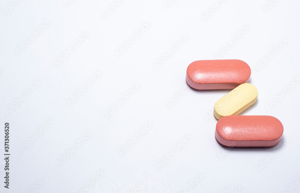 Two brown and one whitish capsule on a white background. With space to write. Two brown and one whitish capsule on a white background. With space to write.