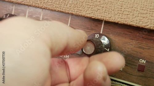 Vintage guitar amplifier knobs up close.  Dusty reverb and chorus dials being turned by hand.  Caucasian male hand turning the knobs multiple times.