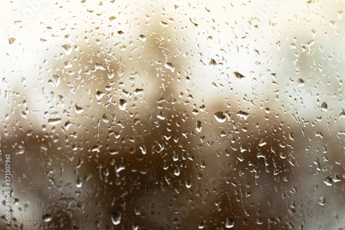 Close-up orange rain drops on the glass, rainy season in autumn.